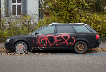 Seitenansicht eines stillgelegten Autos mit Radkralle auf einem Parkplatz. Die Aufnahme stammt aus einer wöchentlichen fotografischen Langzeitdokumentation.
