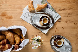 Zwei Espressotassen und ein Croissant auf gedecktem Tisch im Haarcafé