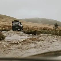 off-roading-car-stuck-water-stream-nature.webp