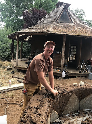 Robert building a cob house