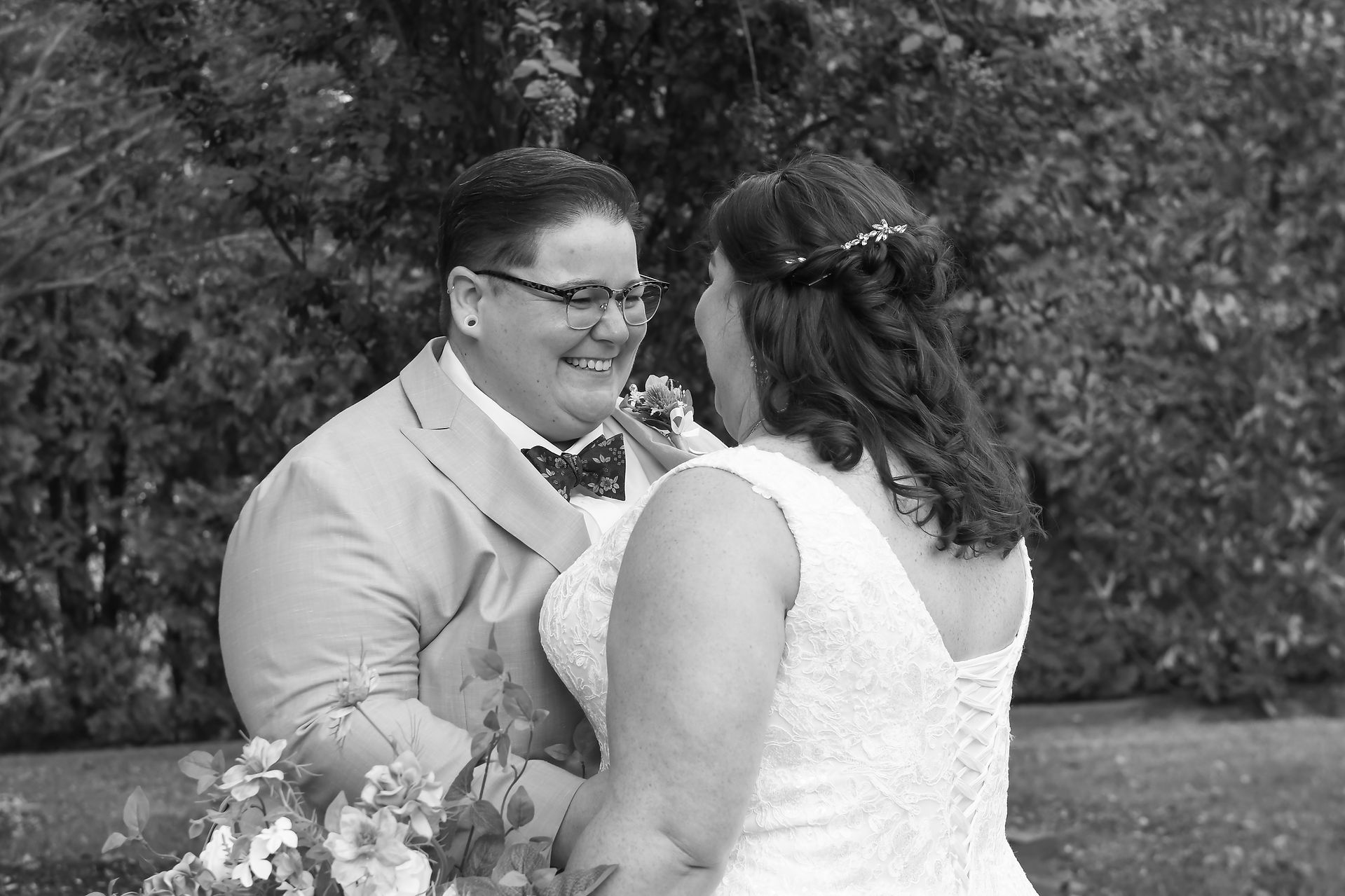 A newlywed couple sharing a joyful moment in the gardens at The Farmhouse, Delaware.