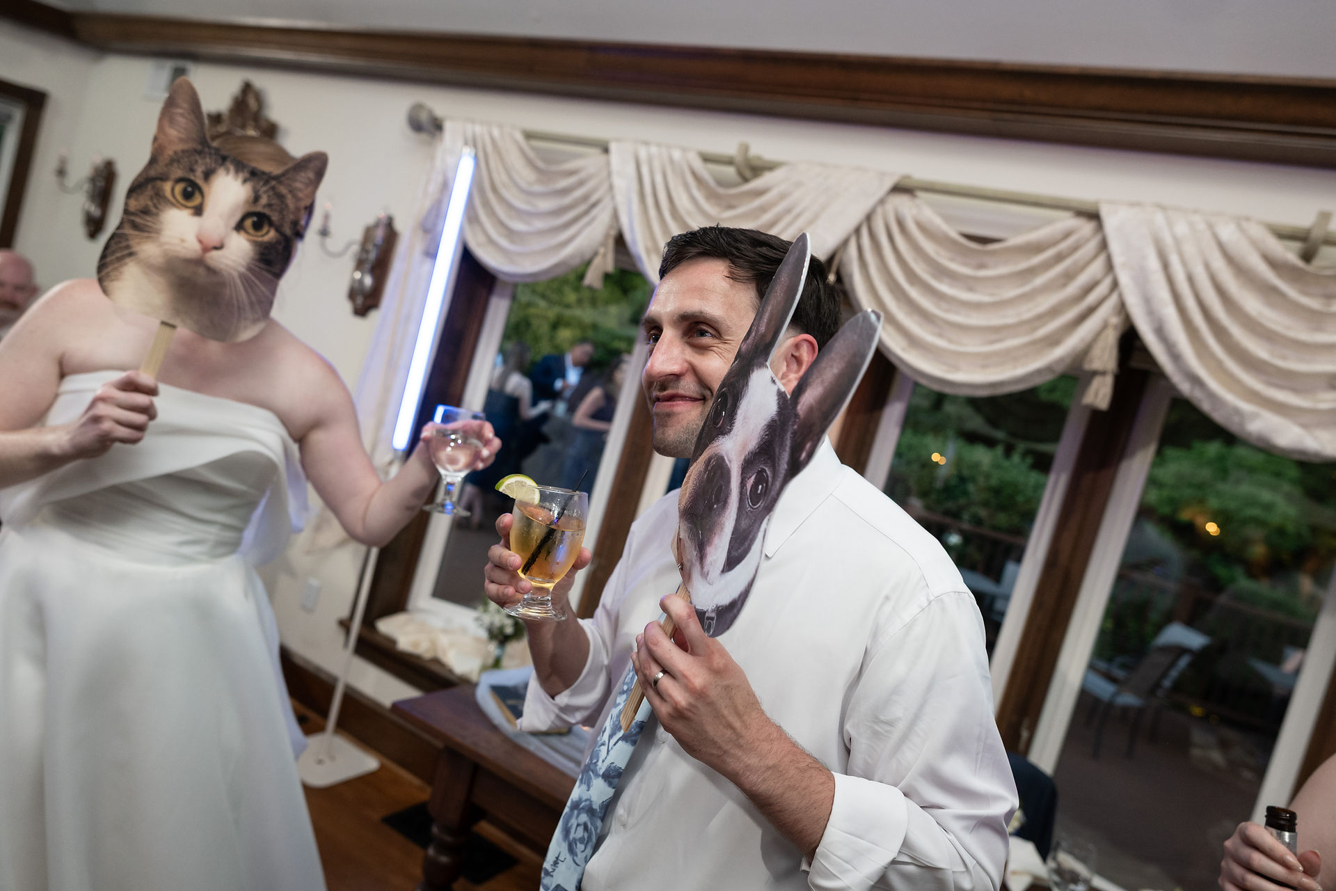 Bride and groom dancing with large pet face cutouts at reception