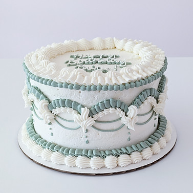 Photo of a take with ornate vintage piping in shades of sage green and white
