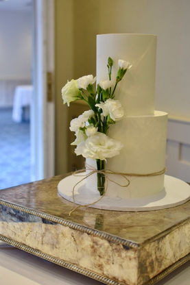 Two tiered white wedding cake with beautiful and subtle flower decorations