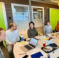 Mensen aan tafel werkend aan klantstrategie