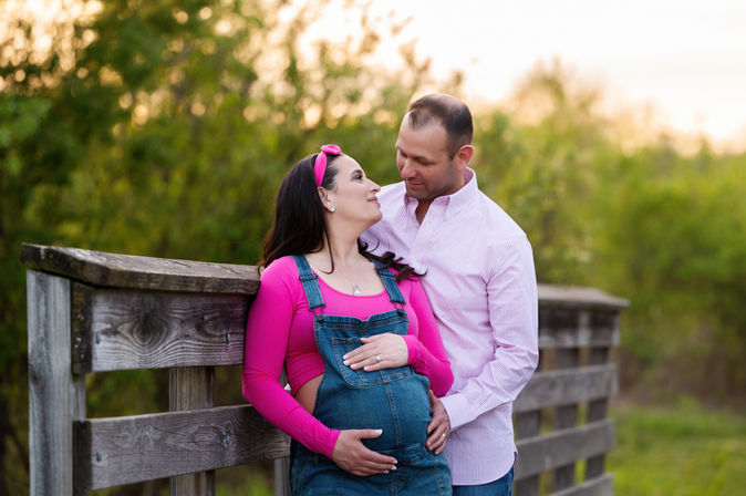 Expecting couple smiling together during sunset maternity session