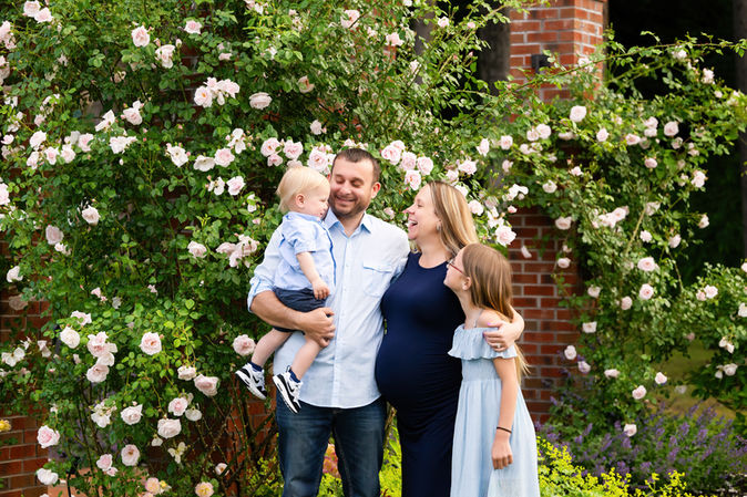 Family standing together in front of blooming white flowers outdoors