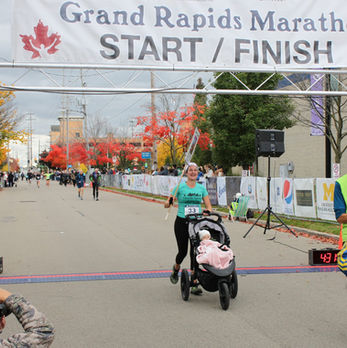 bri terry crossing gr marathon finish line with jogging stroller