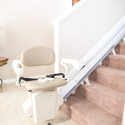 Unoccupied stairlift seat at the bottom of stairs