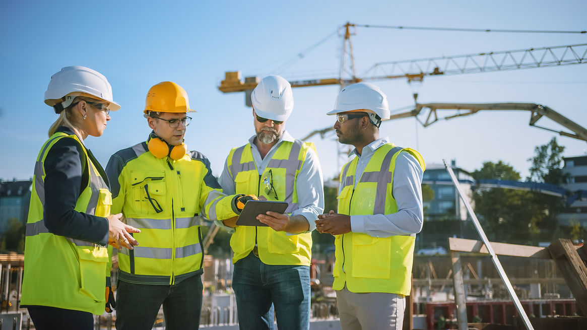 Diverse Team of Specialists Use Tablet Computer on Construction Site. Real Estate Building