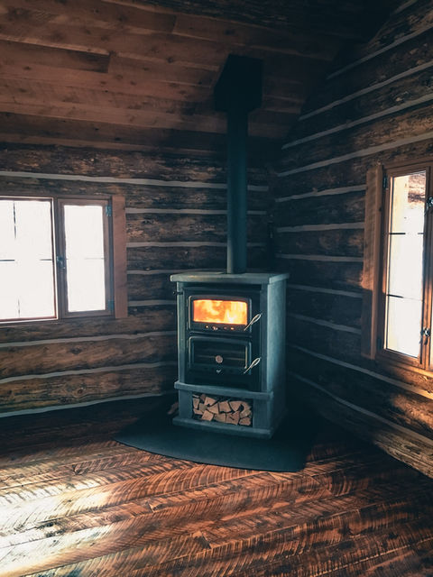 Cozy fireplace in a log cabin with rough sawn flooring