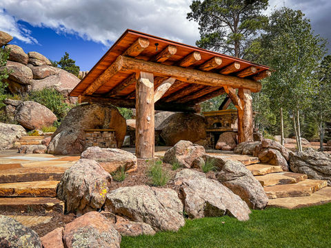 Awesome stone landscaping around a log gazebo