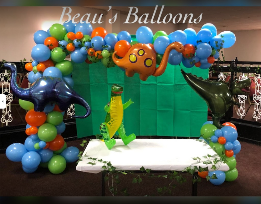 Dino themed balloon display with orange, green and blue balloons