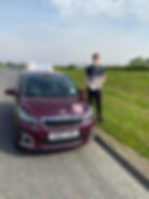 Young man beside learner vehicle at side of road