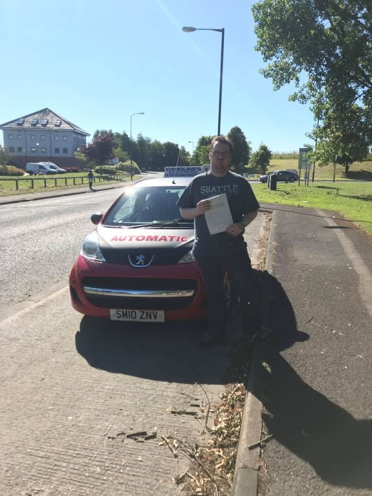 Man next to learner car with pass certificate