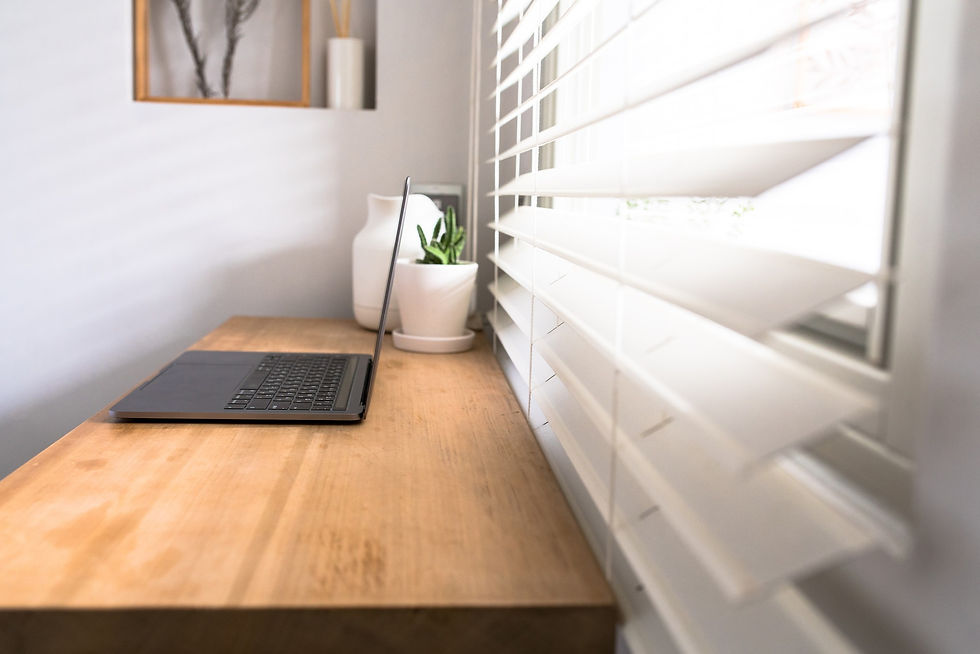 White Venetian blinds covering window next to desk