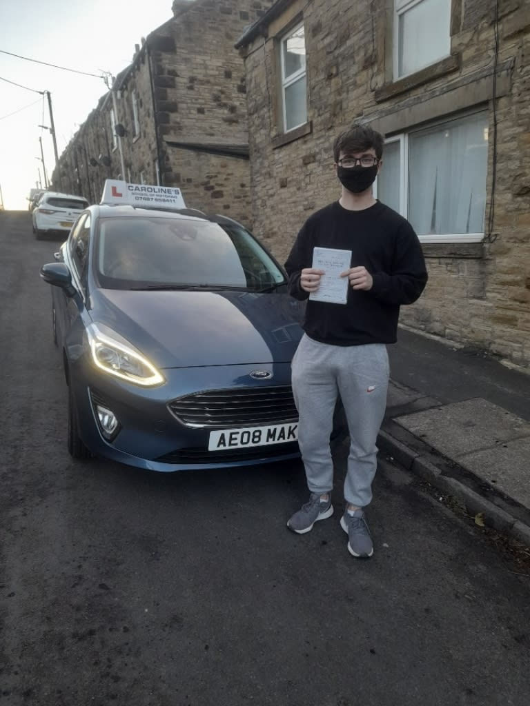 New driver wearing face mask, stood with learner car
