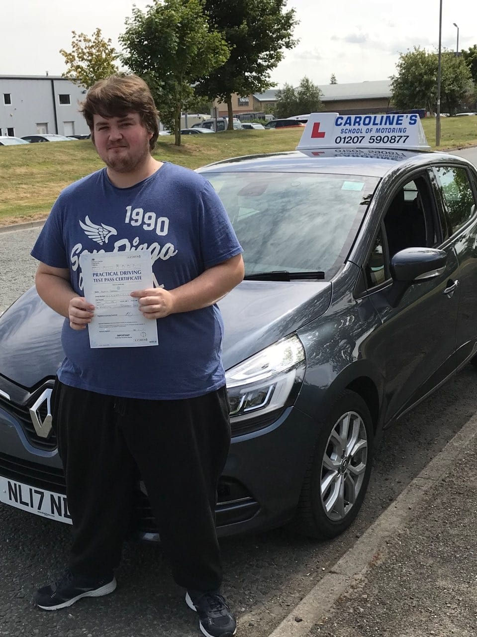 Young male student stood in front of learner vehicle