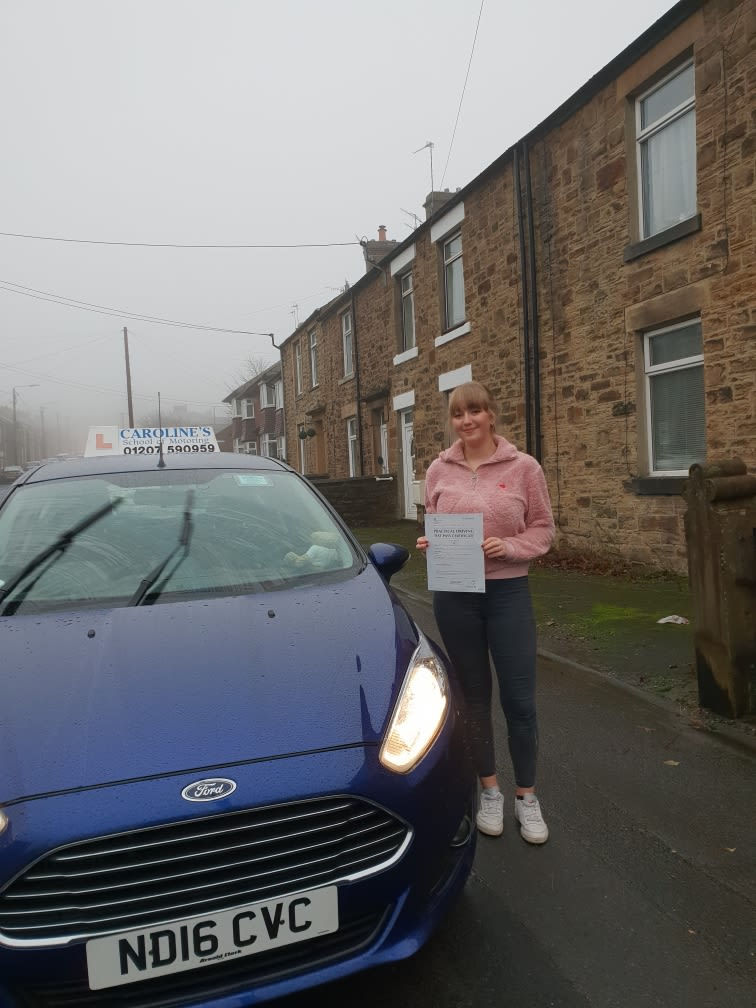 Student next to learner car on a gloomy day