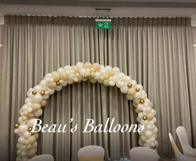 Gold, white and cream balloon arch at wedding venue