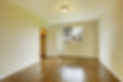 Empty room with wooden flooring and white walls
