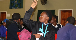 Female student in puma raising hand.jpeg