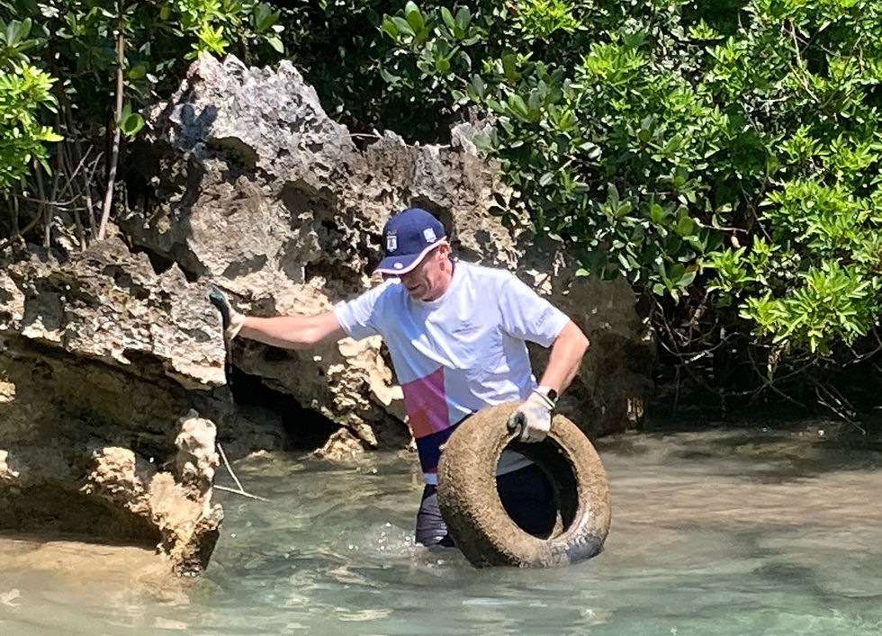 Andrew Murdoch, Governor of Bermuda jumps into the water to retrieve an abandoned tyre