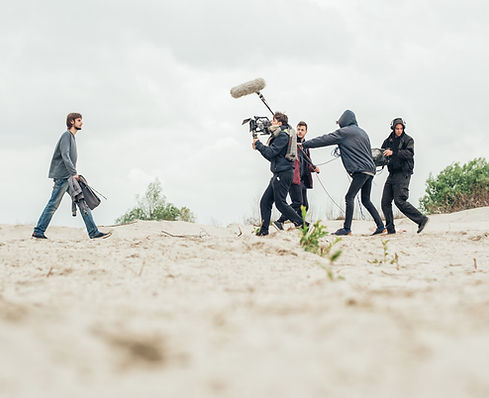 Equipo de producción filmando en exteriores durante una grabación detrás de cámaras
