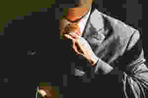 confident man adjusting tie