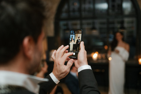 Nahaufnahme von einem Handy, das das Hochzeitspaar fotografiert