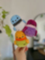 Three stacked colorful crochet by Maya plush toys