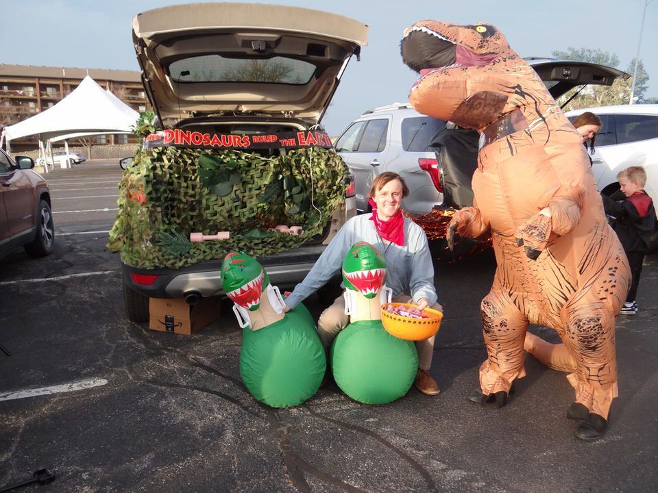 Signature Performance employees in dinosaur costumes at a trunk-or-treat event