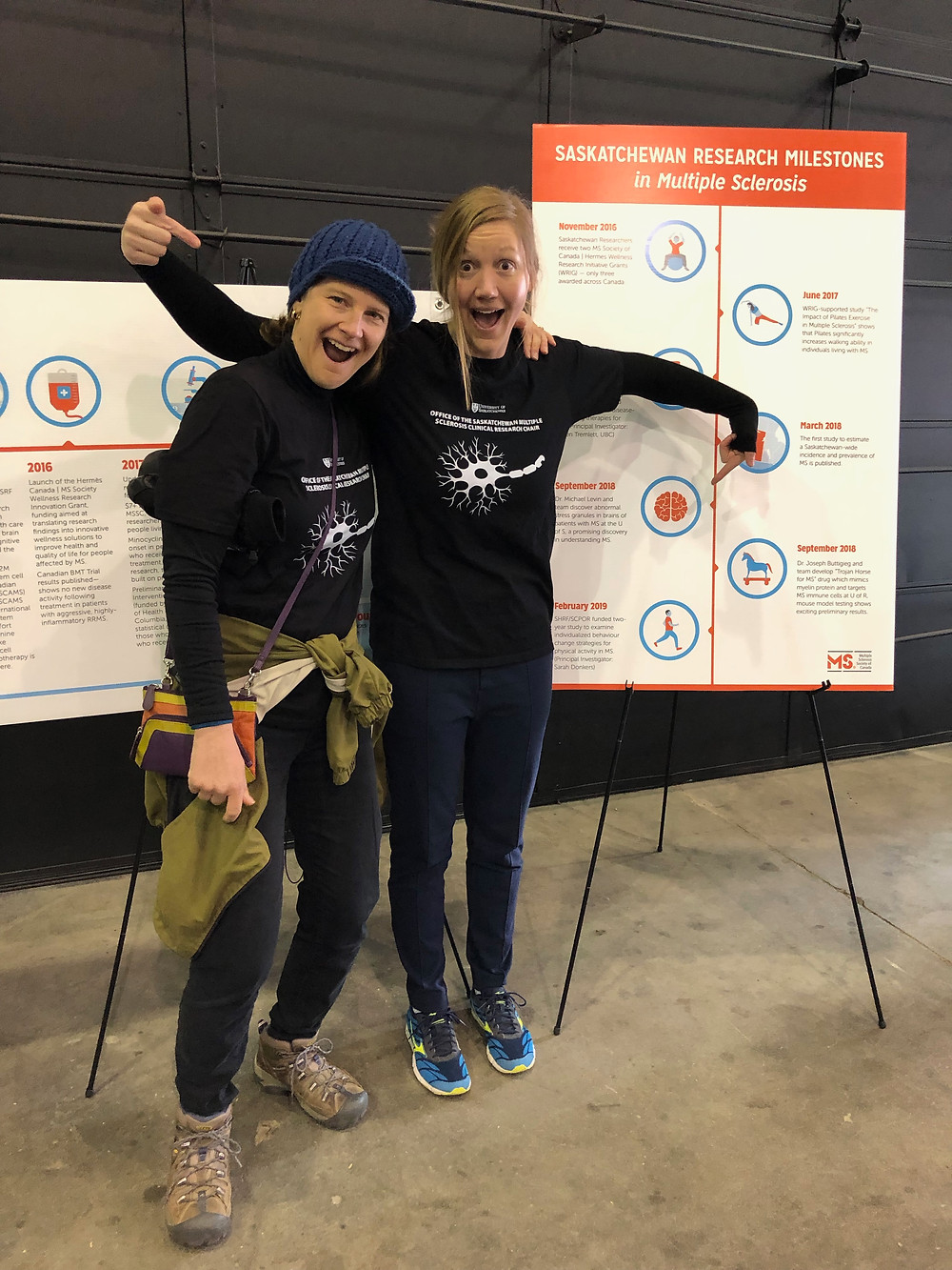 two people pointing at a poster display