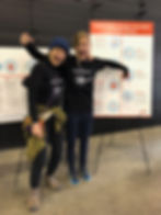 two people pointing at a poster display