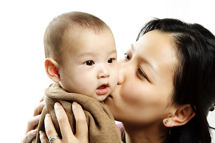 A mother kissing her cute baby son.jpg