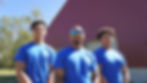Three collision repair team members wearing blue Ashco shirts while standing in front of a red auto repair shop