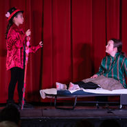 Children performing a dramatic theatre scene on stage at Montreal Children’s Theatre.