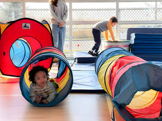 Enfant rampant dans un tunnel de jeu coloré dans le gymnase lors d’une activité de S.Au.S.
