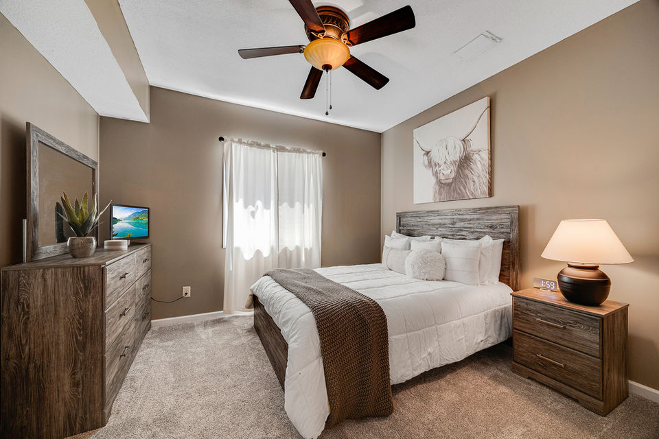Bedroom with bed, dresser, art, and window for a relaxing HOME atmosphere.