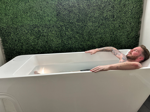 Person taking a cold plunge in an ice bath, a popular recovery trend