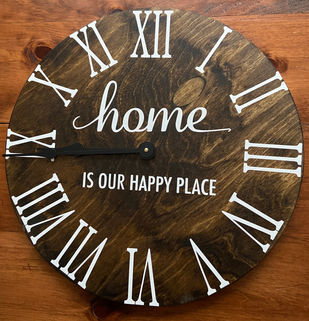 Erin Parsons Designs created this wall clock with permanent vinyl. It has white Roman numerals and the saying "Home is our happy place."