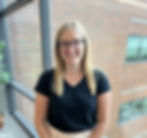 An Ohio State University Physicians' Human Resources team member standing in front of a window at the corporate office.