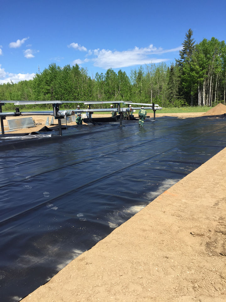 A picture showcasing workers working on a ground covered with a black sheet