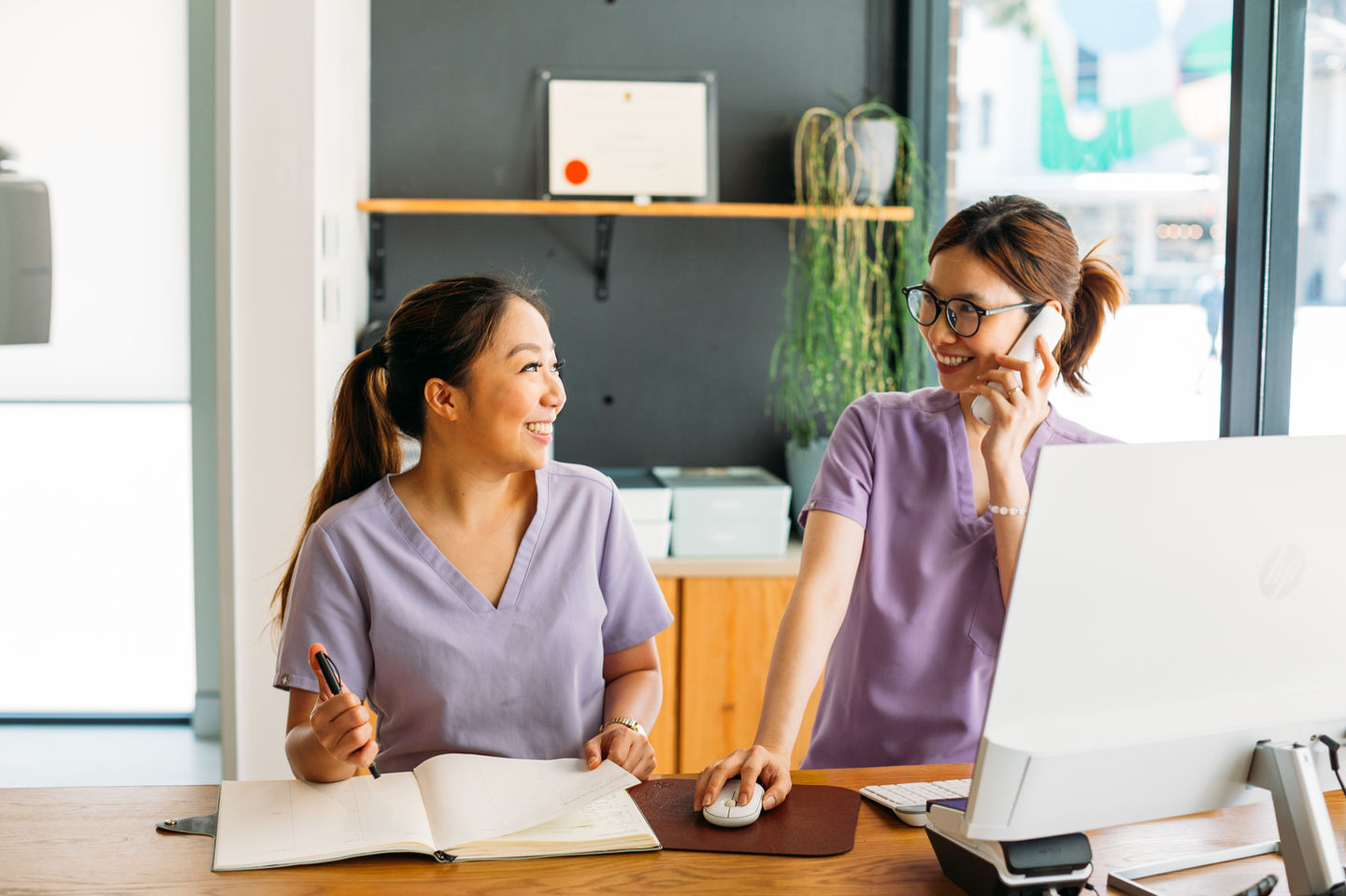 Two smiling receptionists at work