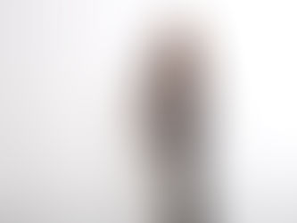 An executive in a photo studio session, leaning against a white wall
