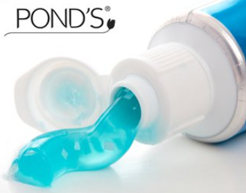 Toothpaste tube with blue toothpaste squirting out. Pond's logo at top.
