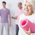 Ältere Frau mit Yogamatte