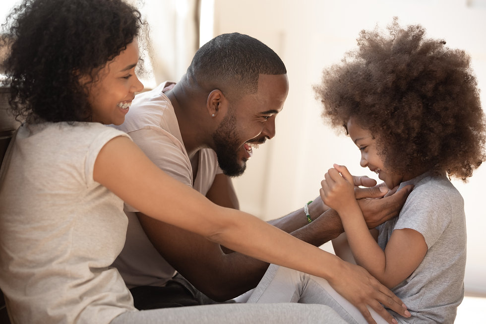 Happy african parents and little cutie daughter spending weekend at home, loving father ti