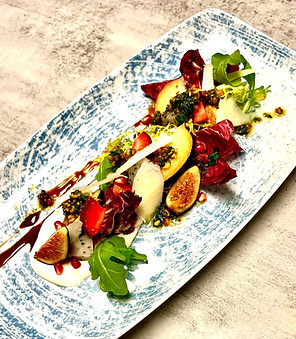 Radicchio and frisee salad with fresh seasonal fruit herbed goat cheese, pomegranate molasses pistachio pesto and pecorino romano.