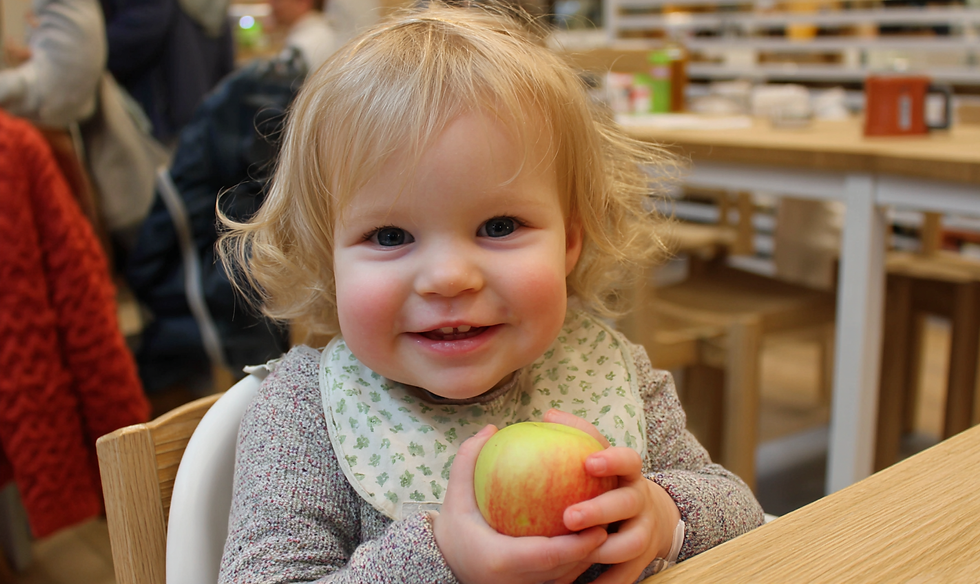 A grandchild eating an apple for free in a supermarket cafe summer 2025 school holidays with their grandparents